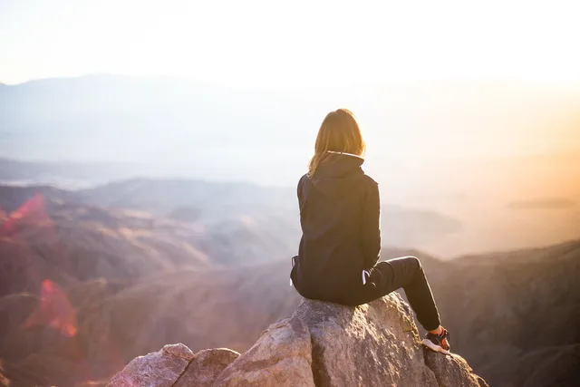people, woman, travel, adventure, trek, mountain, rock, sunset, cliff, black, hoodie, jacket, alone, thinking, nature, freedom. Bio-Based Insulation in Winter Jackets: A Canadian Reality Check