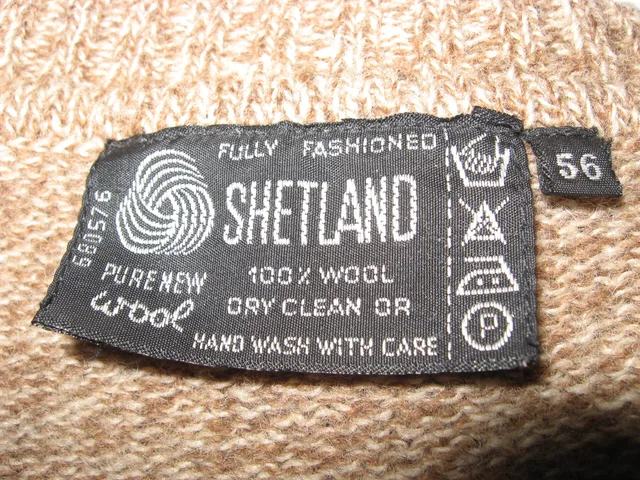 Label with care symbols on a wool sweater. Troubleshooting clothing labels and certifications problems