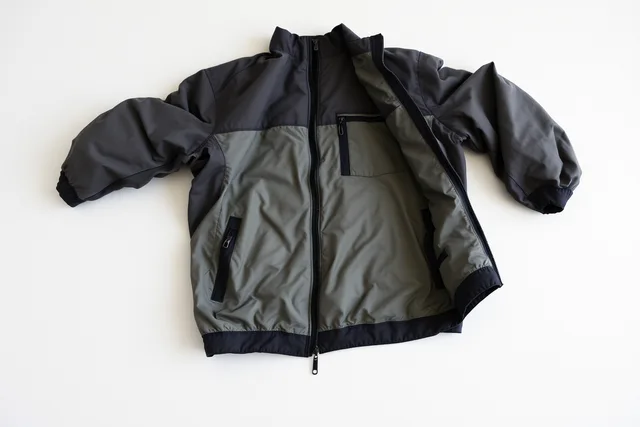 Lightweight jacket with broken main zipper, shell intact, awaiting repair decision. Inside sustainable fashion: follow a documented jacket decision through need, evidence, construction, care
