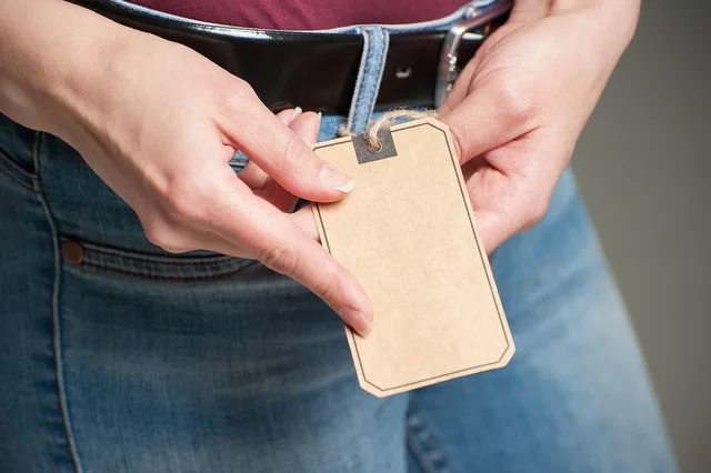 hand, woman, adult, paper, tag, label, jeans, old paper, designer paper, macro, fashion, blue jeans, craft, kraft paper. Canadian Textile Labelling: What the Textile Labelling Act Means for Bio-Based Claims